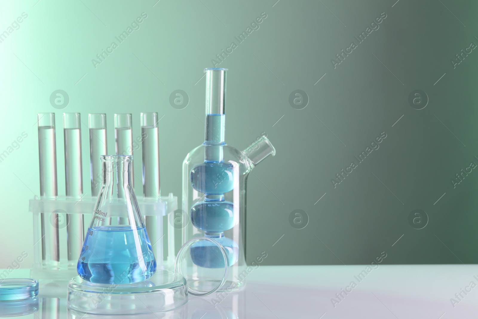 Photo of Laboratory analysis. Different glassware on table against light background, space for text