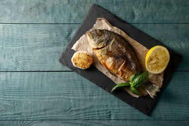 Photo of Delicious dorado fish served on wooden table, top view. Space for text