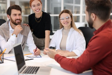 Photo of Team of employees working together in office