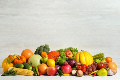 Photo of Assortment of fresh organic fruits and vegetables on light table. Space for text