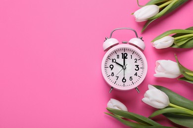 Photo of Alarm clock and beautiful tulips on pink background, flat lay with space for text. Spring time