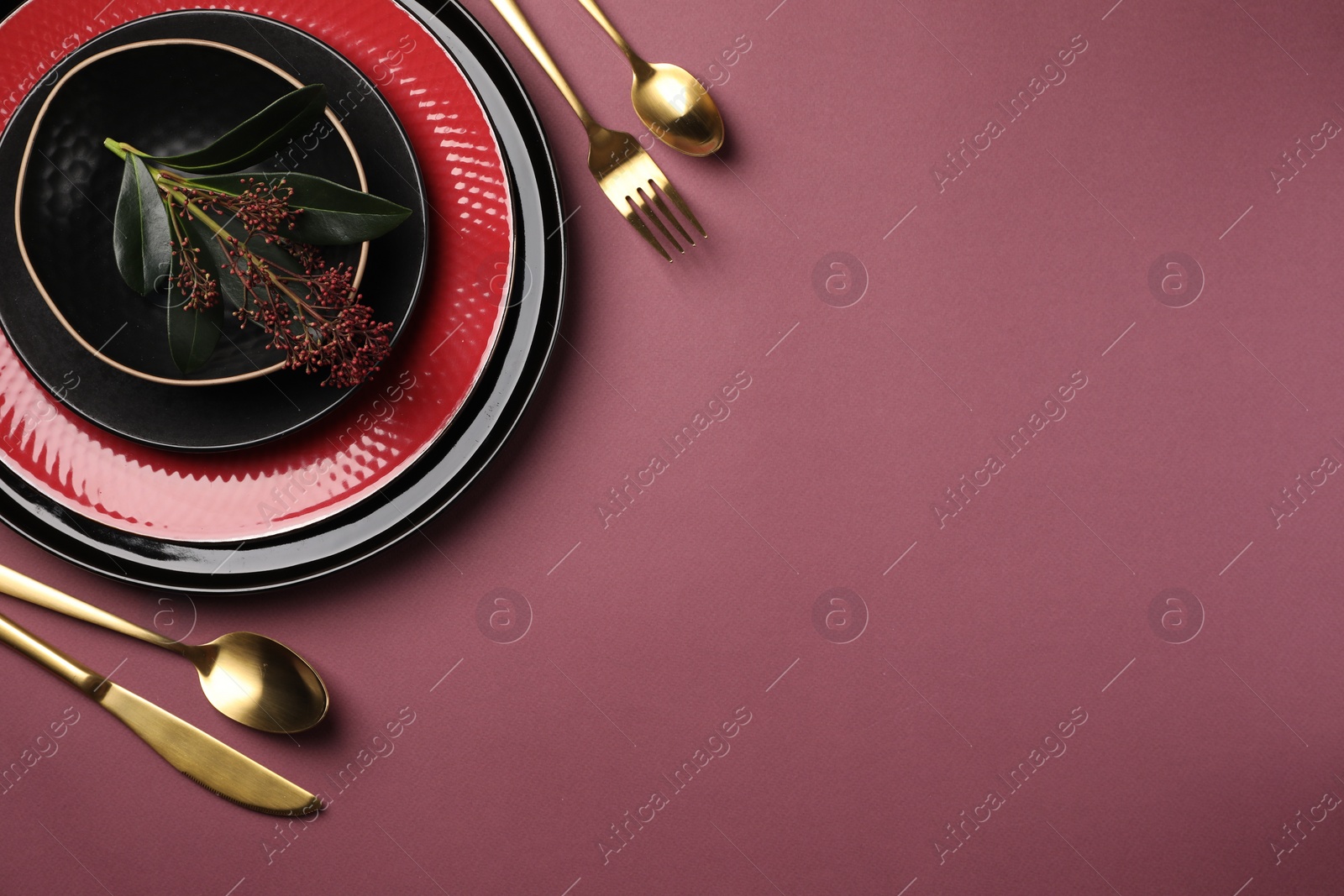 Photo of Stylish table setting with cutlery and floral decor on pink background, flat lay. Space for text