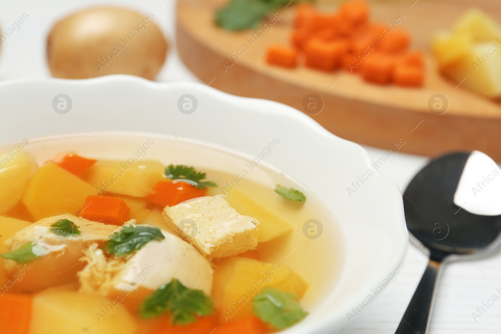 Photo of Dish with fresh homemade chicken soup on table, closeup