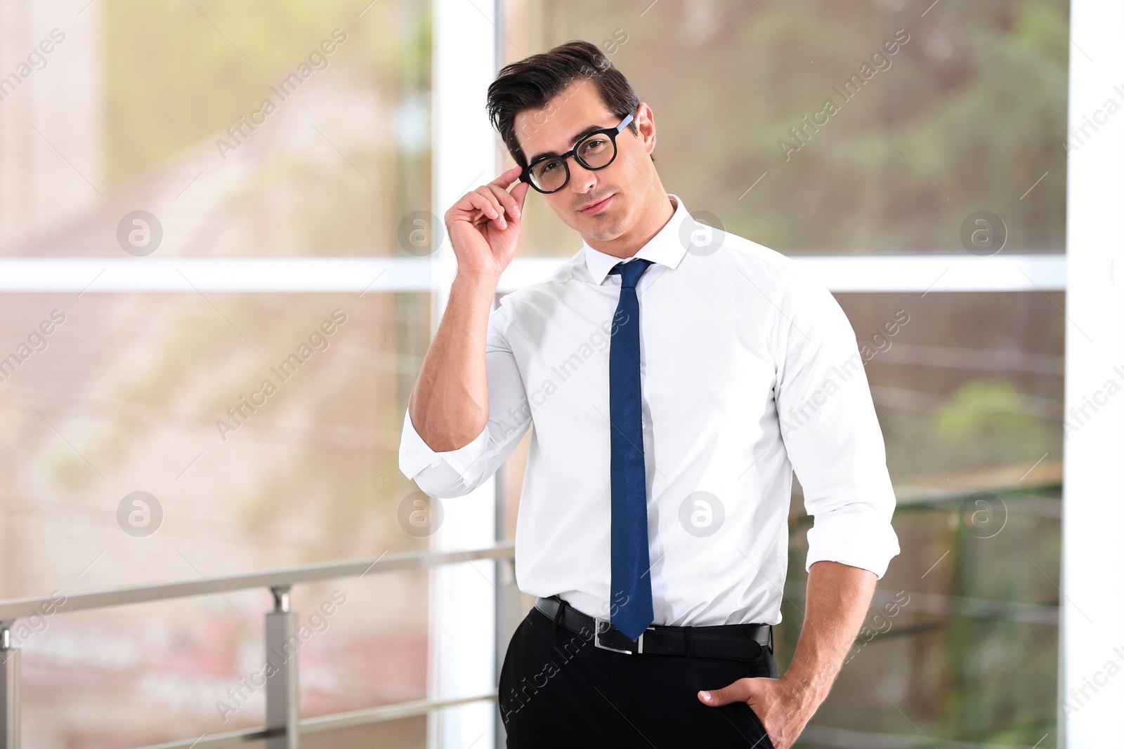 Photo of Handsome young man in stylish clothes with glasses indoors