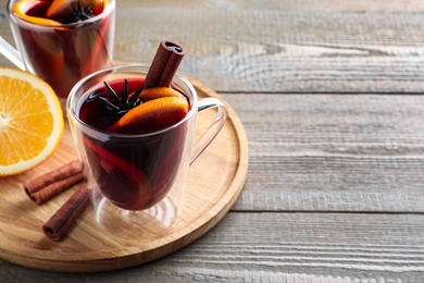 Aromatic mulled wine on wooden table, space for text