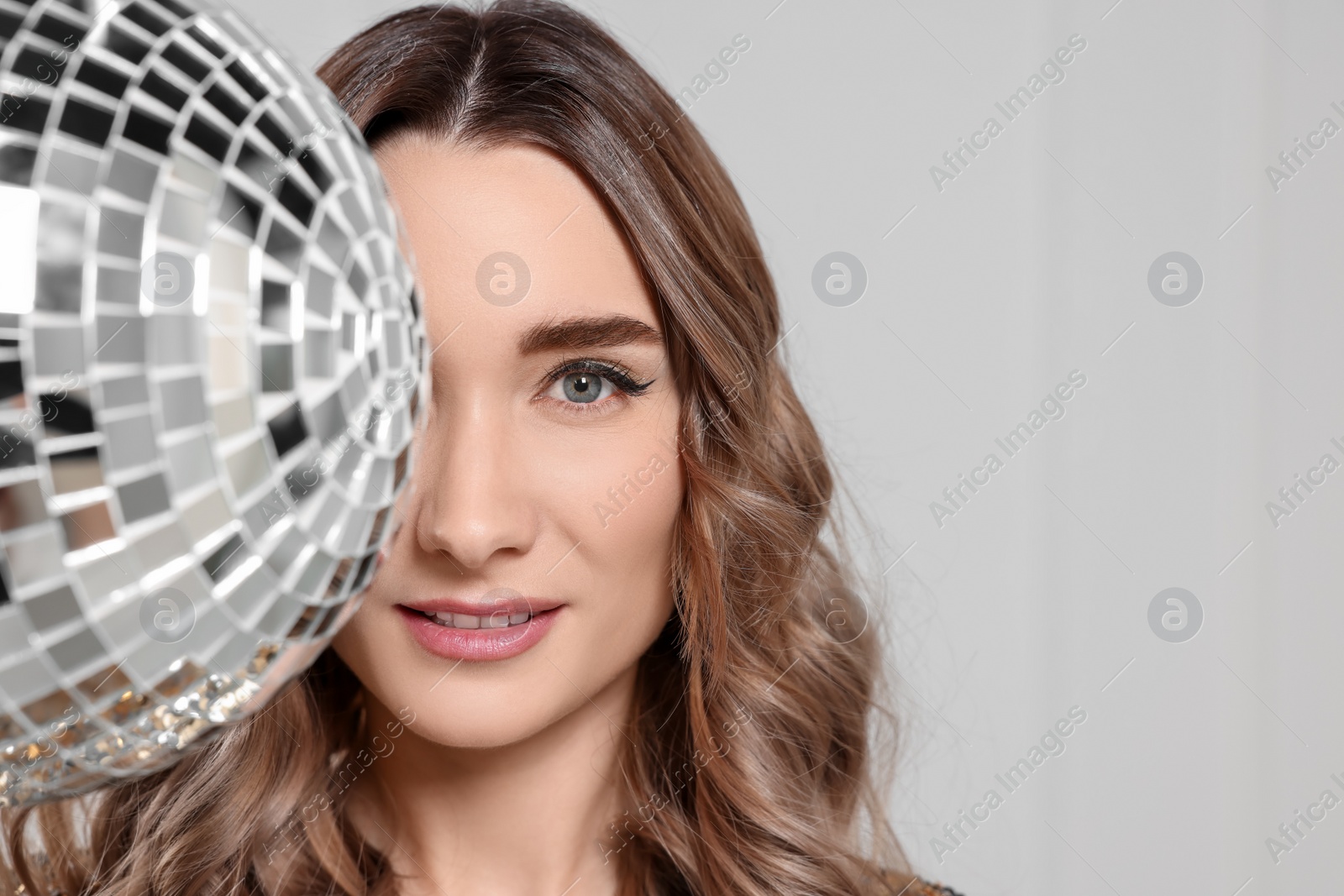 Photo of Beautiful woman with disco ball on white background, space for text