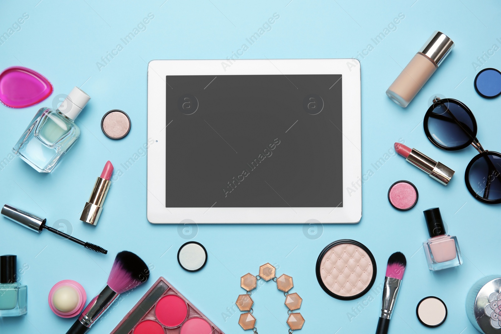 Photo of Flat lay composition with tablet and makeup products for woman on color background