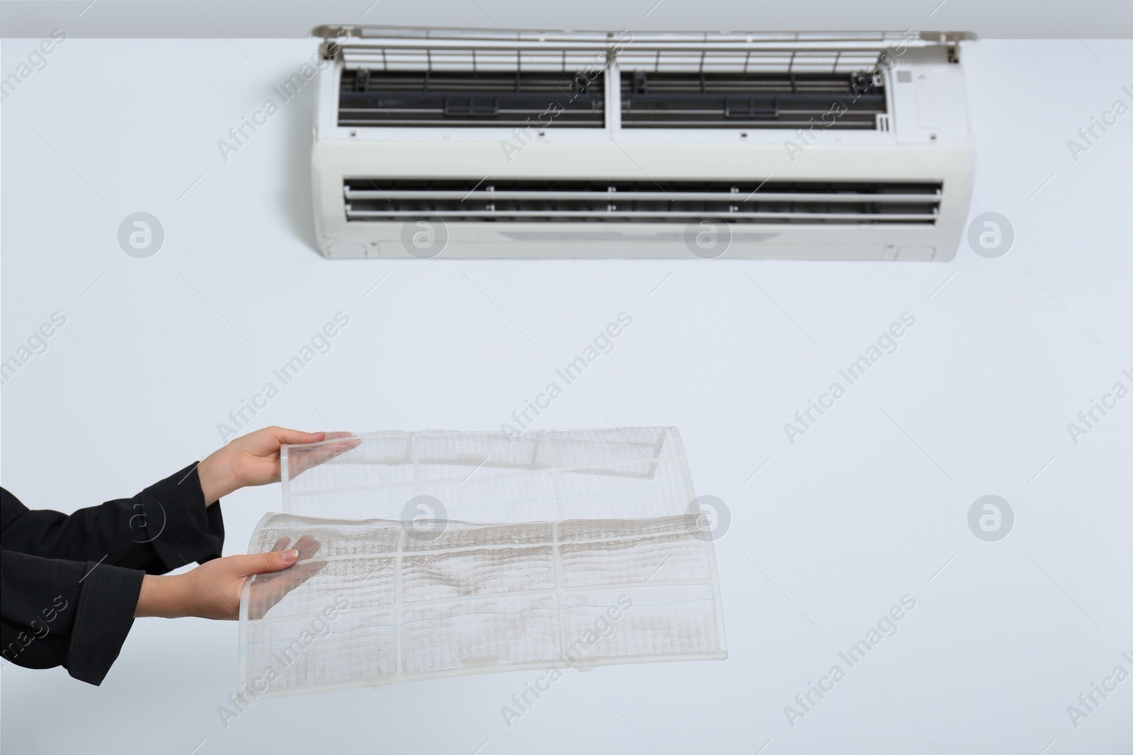 Photo of Woman holding air conditioner filters indoors, closeup