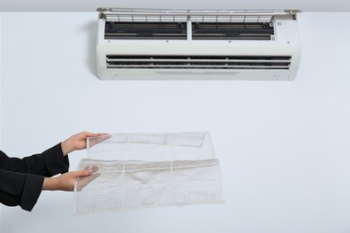 Woman holding air conditioner filters indoors, closeup