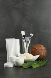 Homemade cosmetic products, tools and fresh ingredients on black table