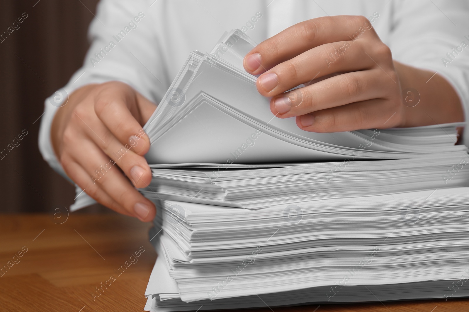 Photo of Man stacking documents at table in office, closeup