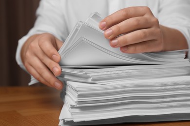 Photo of Man stacking documents at table in office, closeup