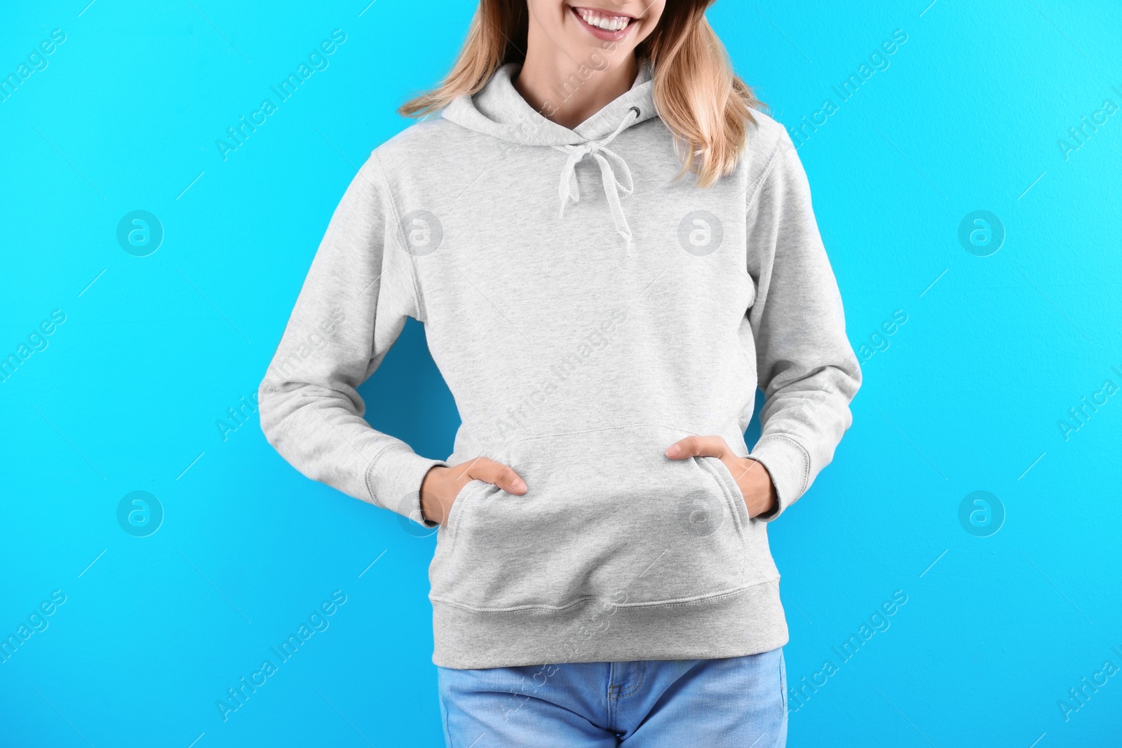 Photo of Woman in hoodie sweater on color background. Space for design