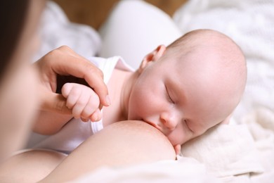 Mother breastfeeding her newborn baby, closeup view