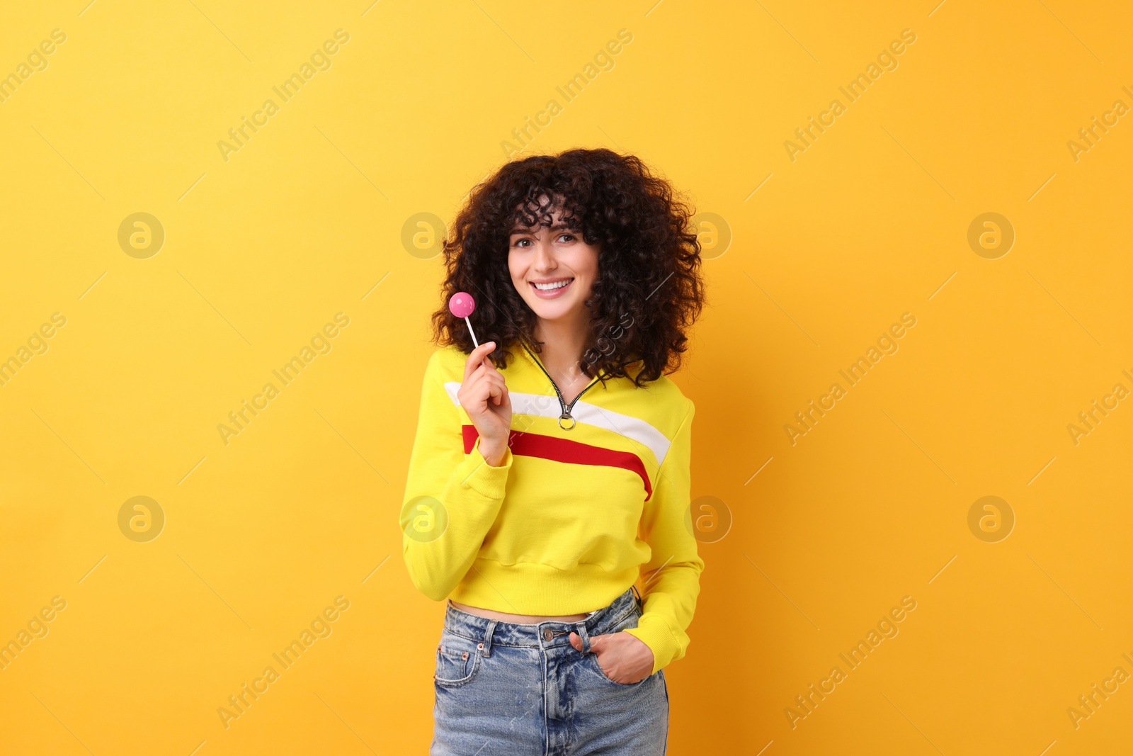 Photo of Beautiful woman with lollipop on yellow background