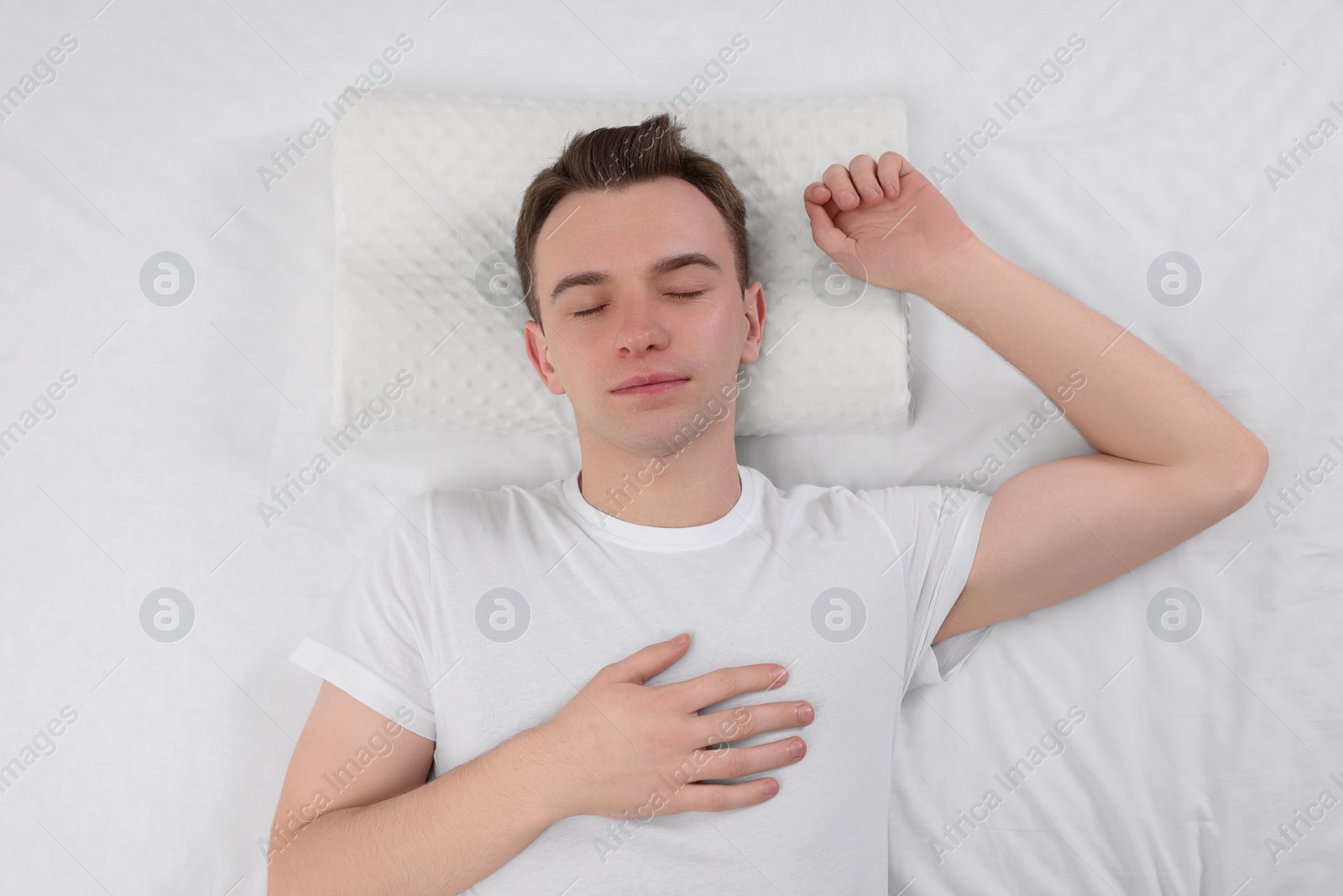 Photo of Man sleeping on orthopedic pillow in bed, top view