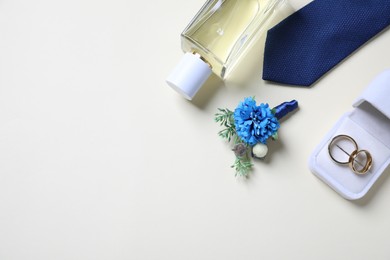 Photo of Wedding stuff. Flat lay composition with stylish boutonniere on light background, space for text
