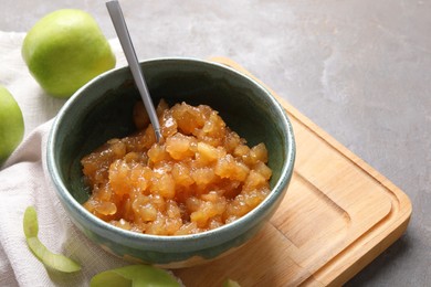 Photo of Delicious apple jam and fresh fruits on grey table