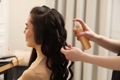 Hair styling. Professional hairdresser working with client in salon, closeup