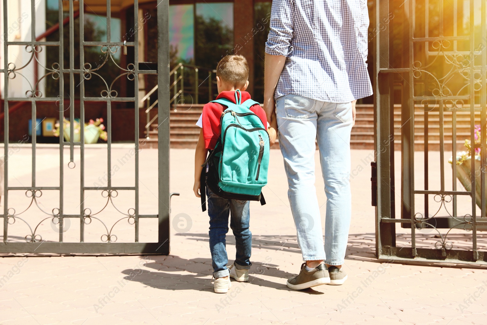 Image of Young father taking his little child to school outdoors