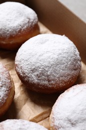 Photo of Delicious buns with powdered sugar in box, closeup