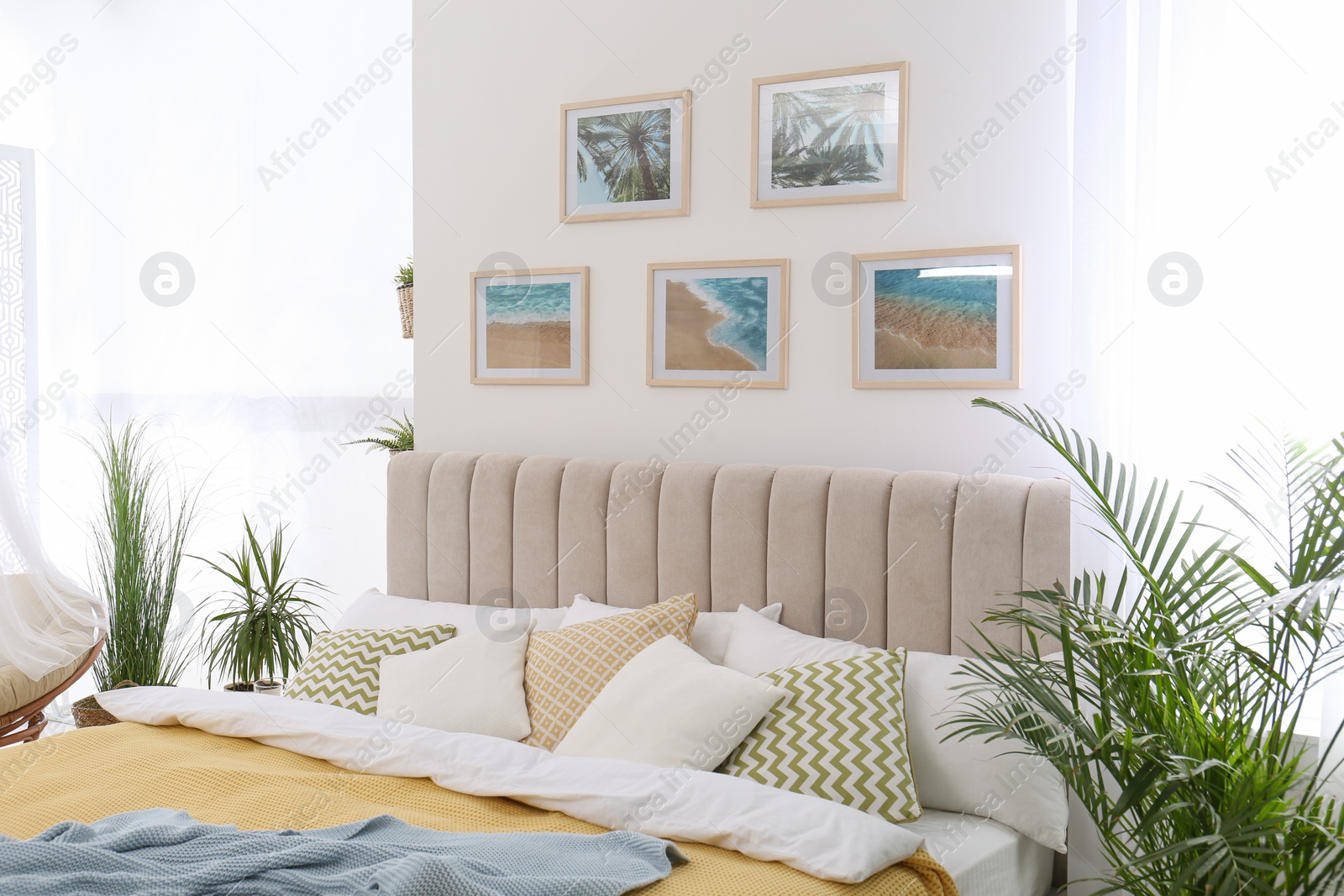 Photo of Stylish room interior with large comfortable bed and beautiful paintings