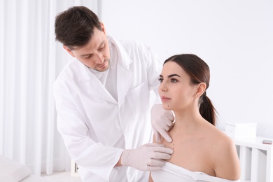 Doctor examining patient in clinic. Visiting dermatologist