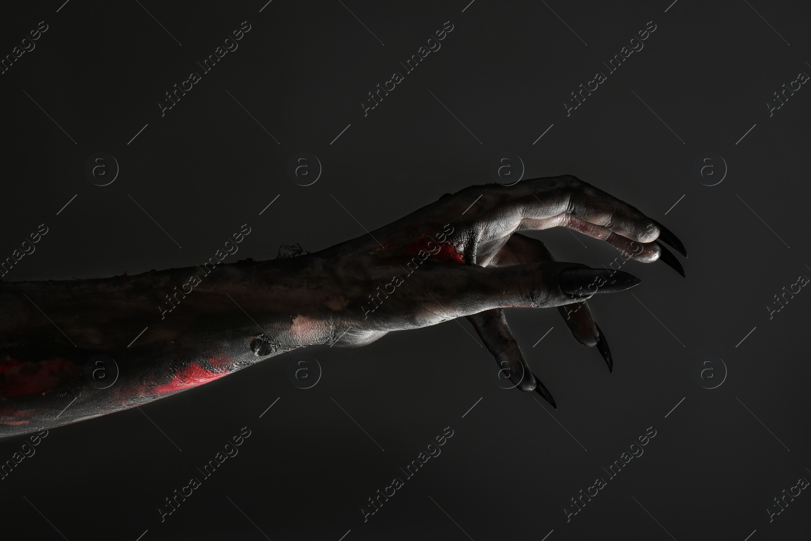 Photo of Scary monster on black background, closeup of hand. Halloween character