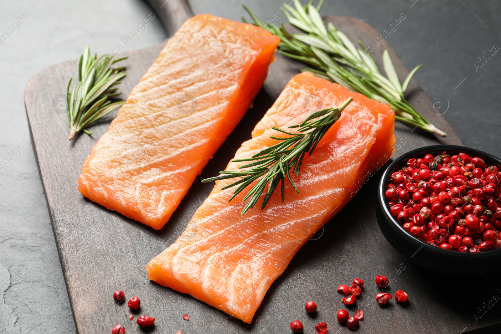 Photo of Fresh raw salmon and ingredients for marinade on black table, closeup