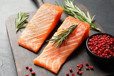 Fresh raw salmon and ingredients for marinade on black table, closeup