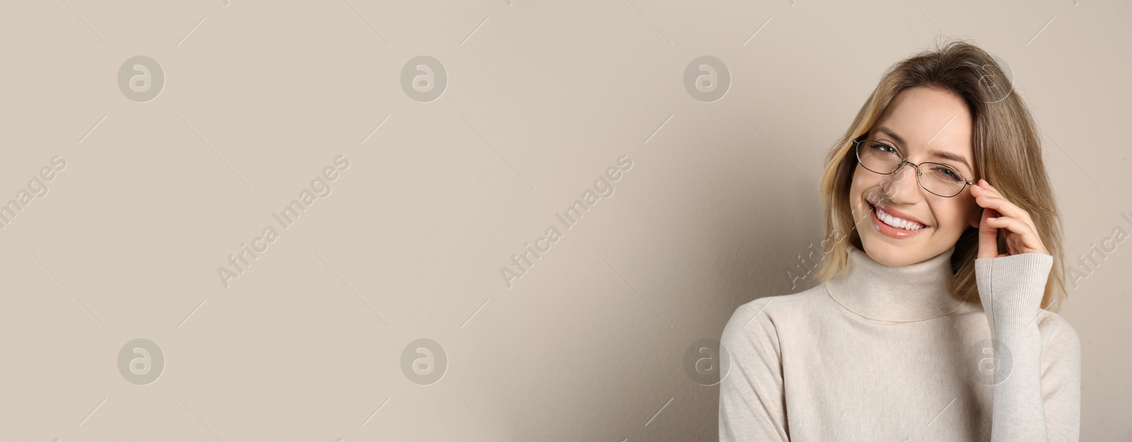 Photo of Portrait of happy young woman with beautiful blonde hair and charming smile on beige background. Space for text