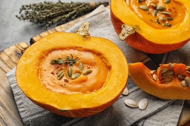 Photo of Tasty cream soup served in pumpkin on table