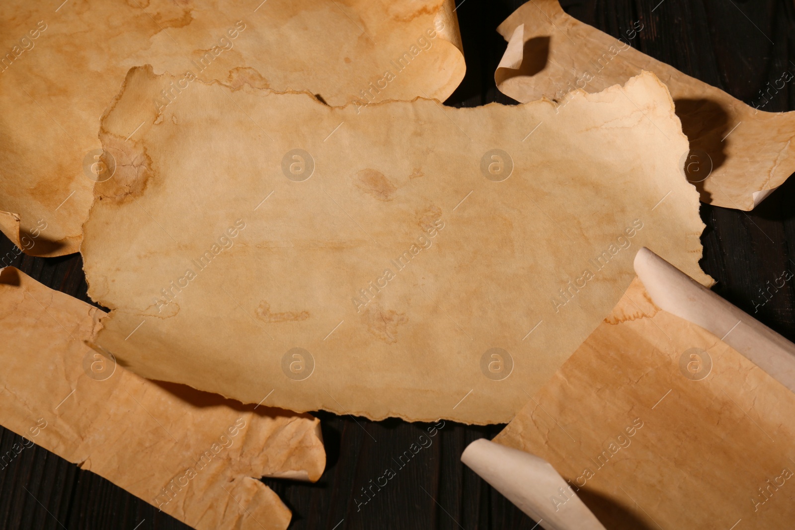 Photo of Sheets of old parchment paper on wooden table