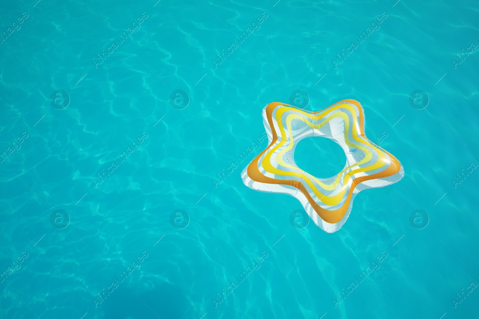 Photo of Star shaped inflatable ring floating in swimming pool on sunny day, above view. Space for text