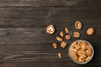 Flat lay composition with walnuts and space for text on wooden background