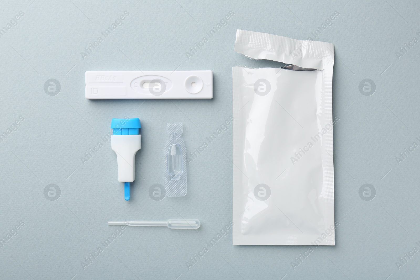 Photo of Disposable express test kit on light blue background, flat lay