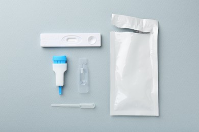 Photo of Disposable express test kit on light blue background, flat lay