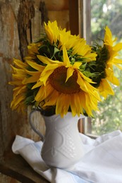 Photo of Beautiful sunflowers in vase near window indoors