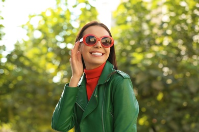 Photo of Beautiful woman wearing red sunglasses in green park