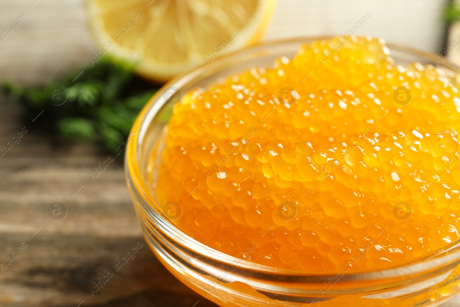 Photo of Fresh pike caviar in bowl on wooden table, closeup