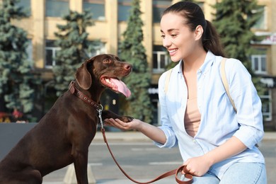 Young woman with her German Shorthaired Pointer dog on city street