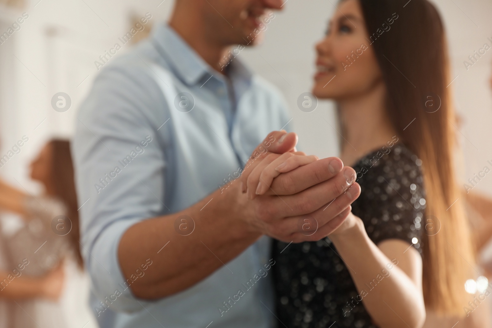 Photo of Young couple dancing at party, focus on hands