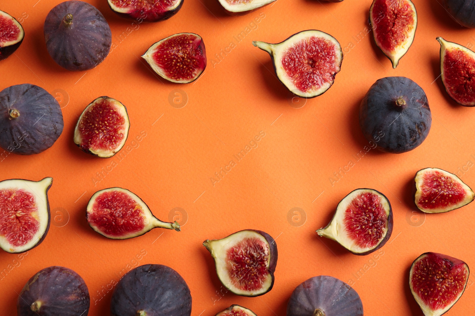 Photo of Delicious ripe figs on orange background, flat lay. Space for text