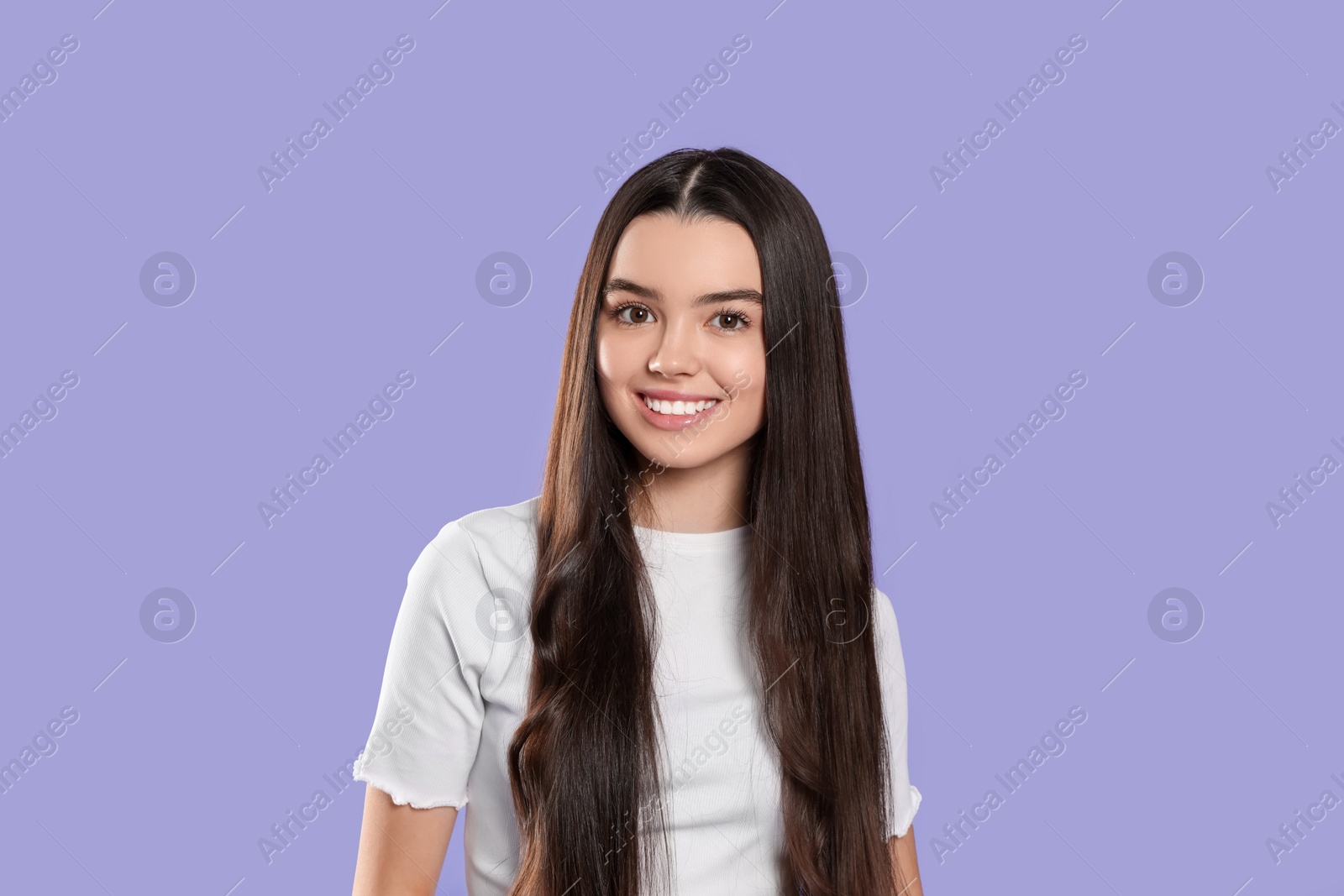 Photo of Portrait of happy teenage girl on violet background