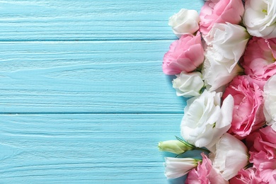 Photo of Flat lay composition with beautiful Eustoma flowers on wooden background