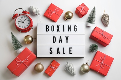 Lightbox with phrase BOXING DAY SALE and Christmas decorations on white background, flat lay
