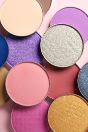 Photo of Different beautiful eye shadows on pink background, flat lay