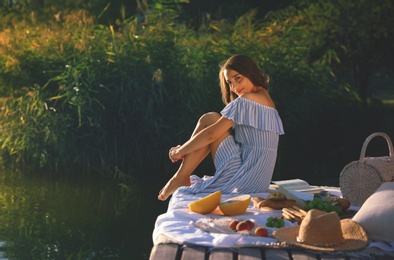 Young woman spending time on pier at picnic