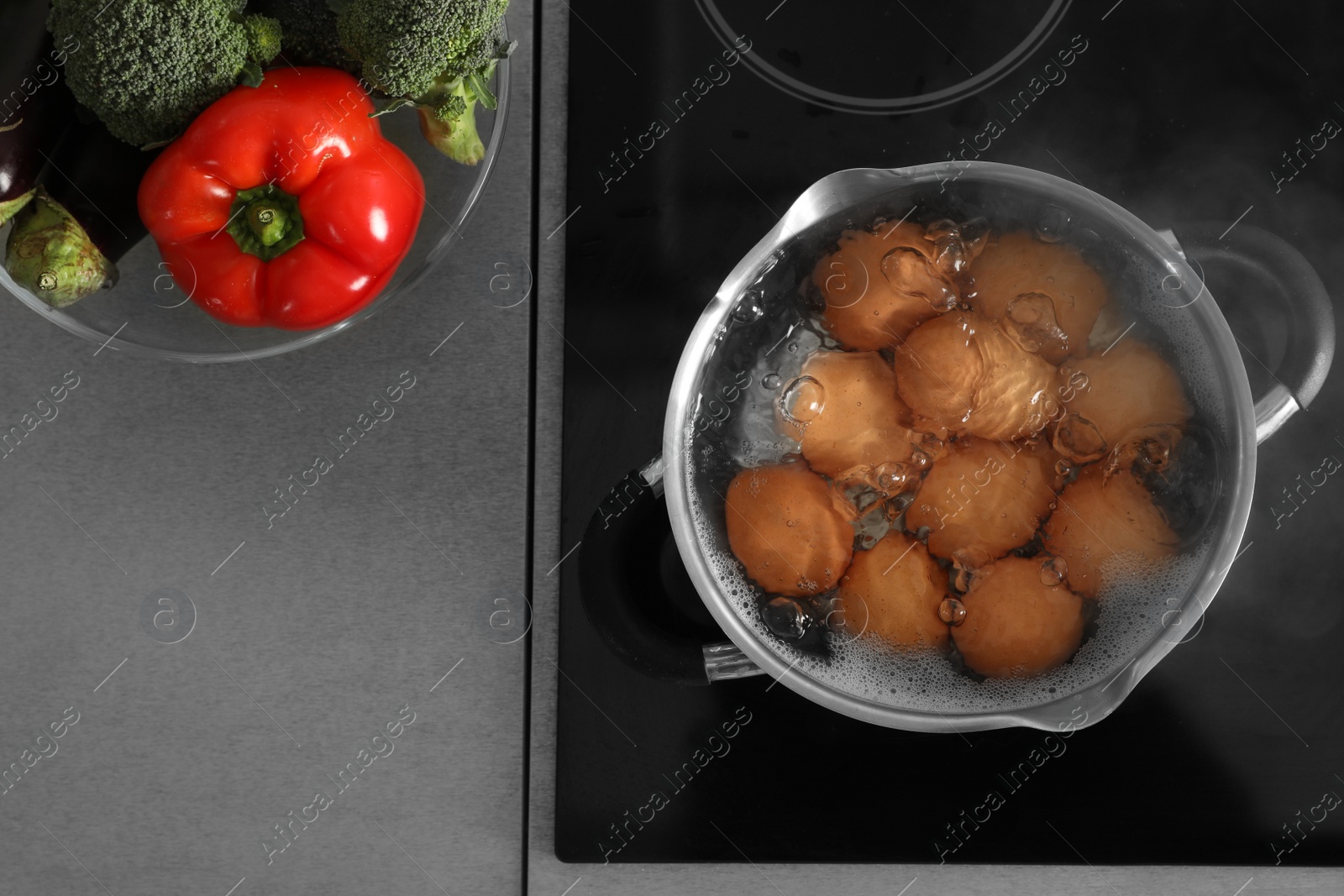 Photo of Cooking chicken eggs in pot on electric stove, top view. Space for text