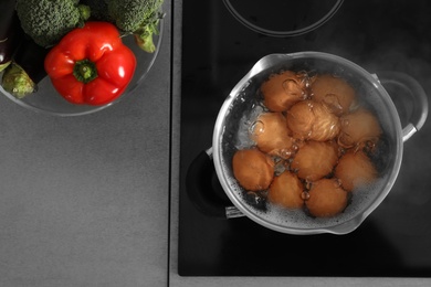 Cooking chicken eggs in pot on electric stove, top view. Space for text